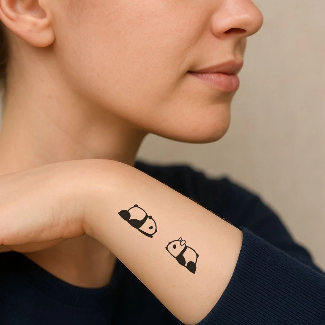 Lying down panda duo temporary tattoo, one with bow